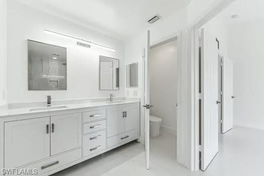 Bathroom featuring double vanity and toilet