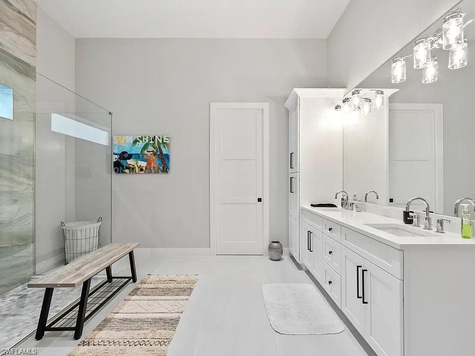 Spacious bathroom featuring a dual vanity with white cabinetry and quartz countertops