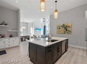 Central kitchen island featuring a rectangular undermount sink, gooseneck faucet, and integrated dishwasher