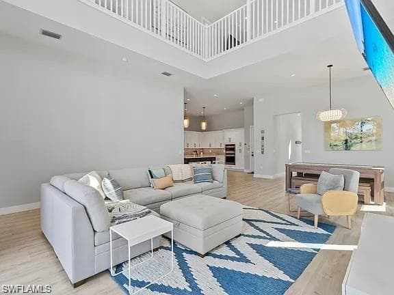 Two-story living area with high ceilings and wood-finish flooring