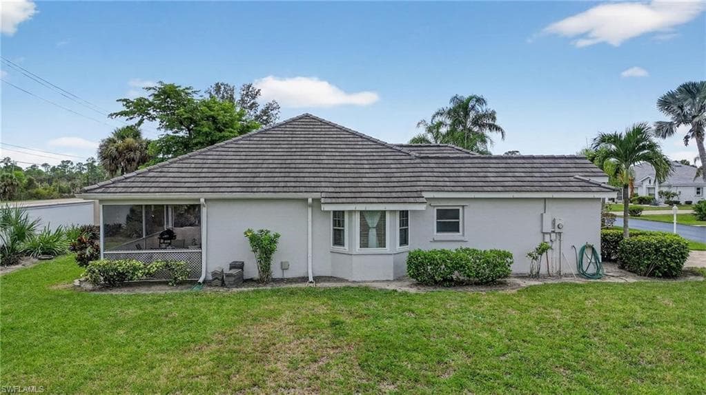 Exterior featuring a neutral stucco finish, a screened lanai, a bay window, and a textured shingle roof