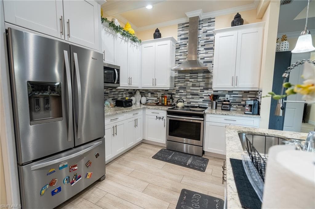 Kitchen featuring white shaker-style cabinetry, stainless steel appliances, granite countertops, and a mosaic tile backsplash