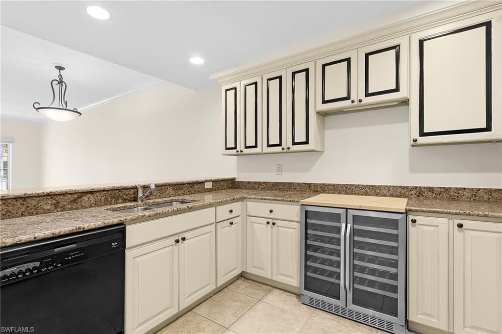Kitchenette with light-toned cabinetry, granite countertops, and a dual-zone beverage refrigerator
