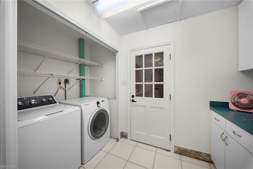 Utility area featuring a white paneled door with glass inserts, white cabinetry, a teal countertop, white wire shelving, and square tile flooring