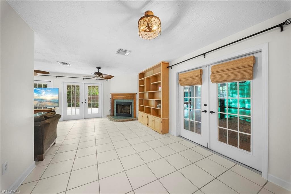 Spacious room featuring light-colored tile flooring, white walls, and multiple ceiling fans