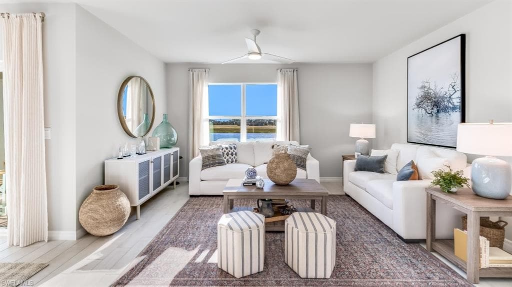 Model home. Living area with wood finished floors and a ceiling fan
