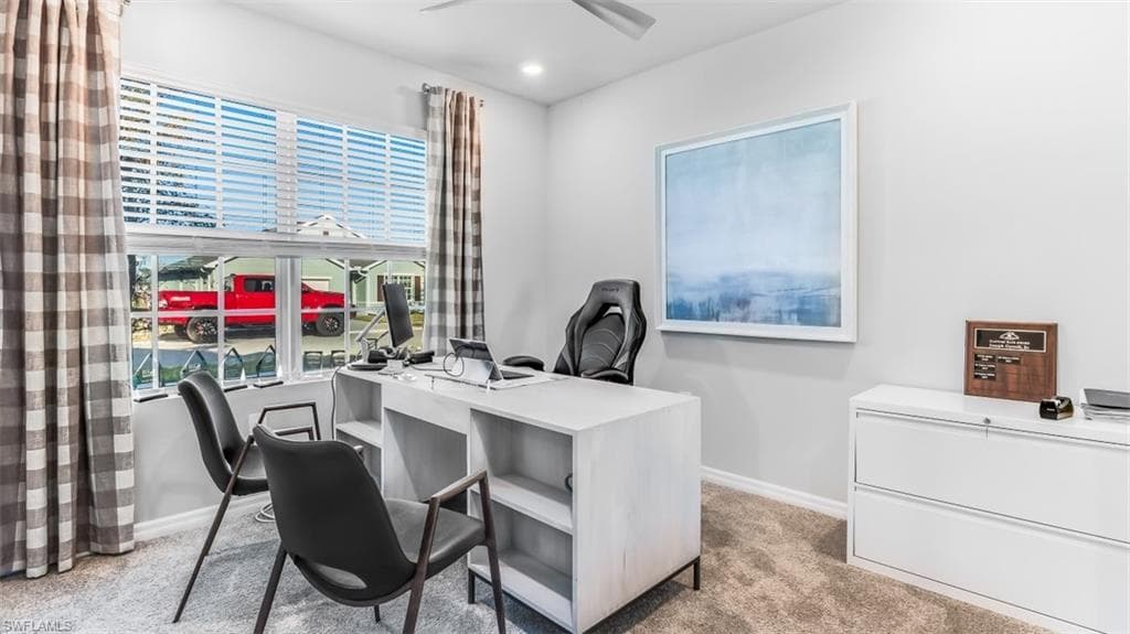 Model home. Office area featuring light colored carpet and ceiling fan