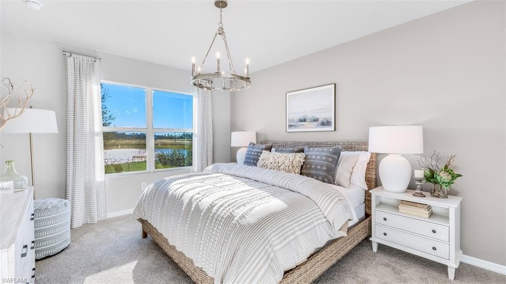 Model home. Bedroom with carpet, a water view, and a chandelier