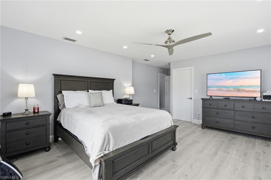 Spacious room featuring light-toned walls and wood-finish flooring