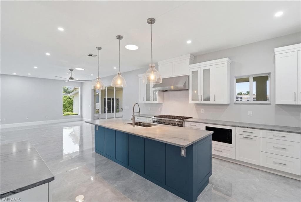 Spacious kitchen featuring a large island with a sink and pendant lighting