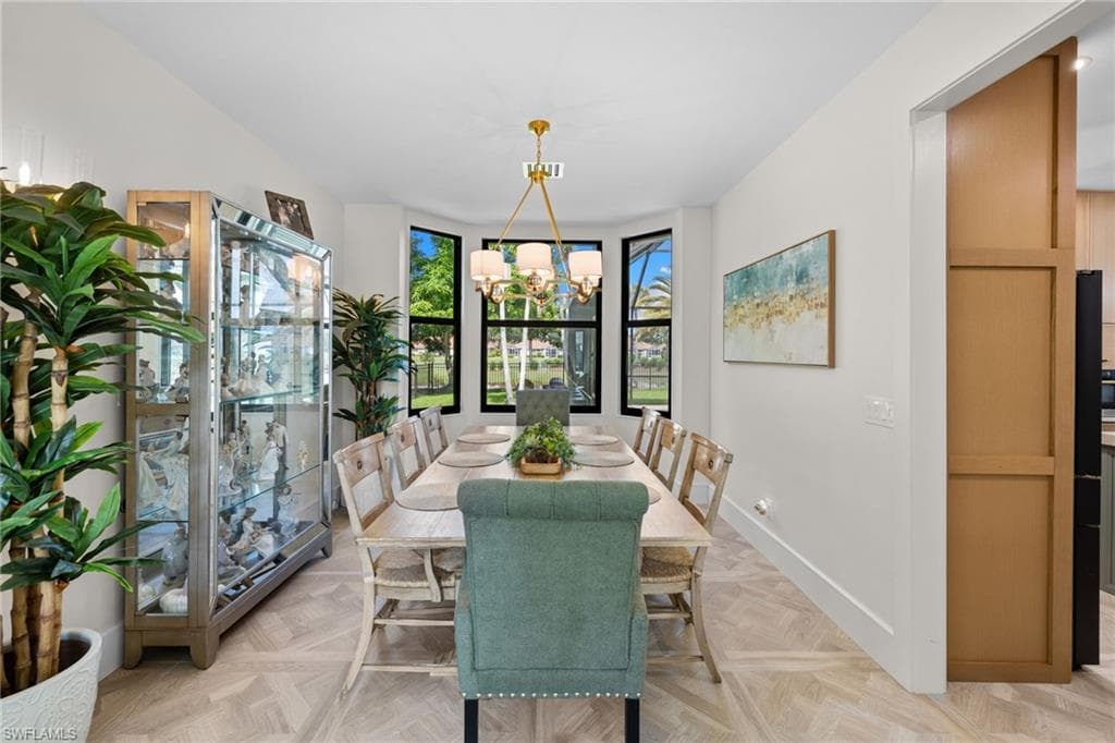 Dining area featuring a bay window, wood-finish flooring, white walls, and a contemporary chandelier