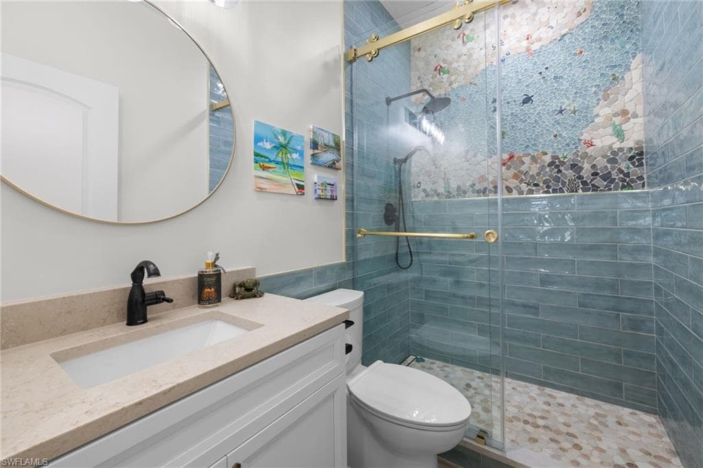 Bathroom featuring a glass-enclosed shower with custom mosaic tile and blue subway tile surround