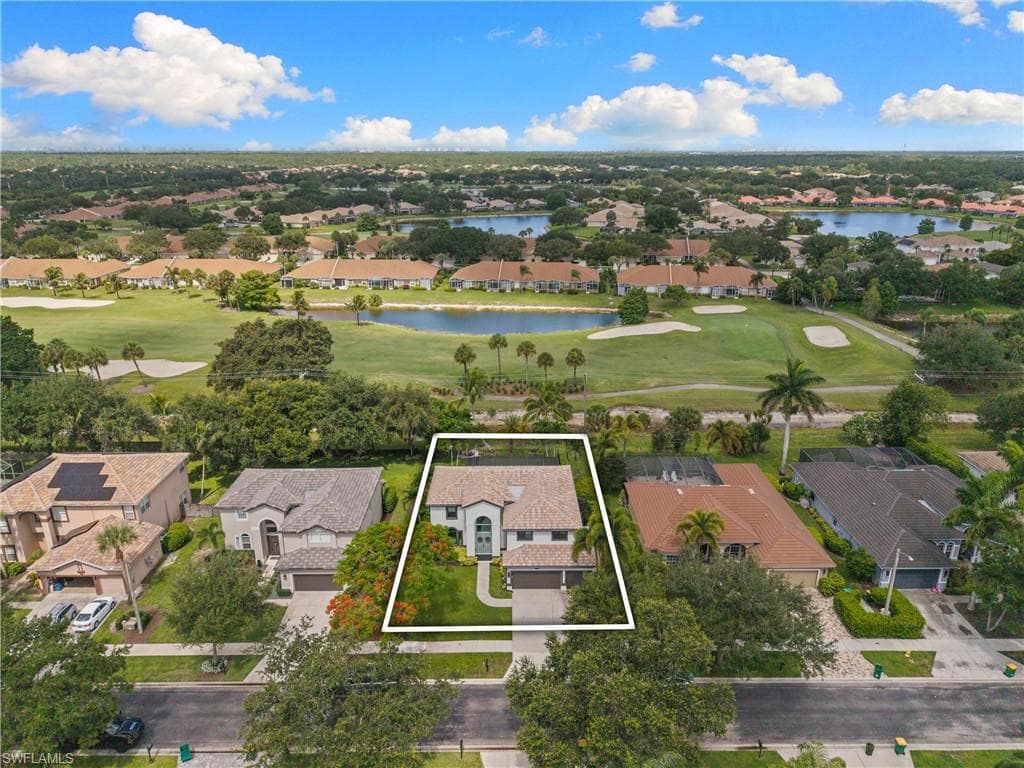 Two-story residence featuring a tile roof, an integrated two-car garage, and a manicured front lawn
