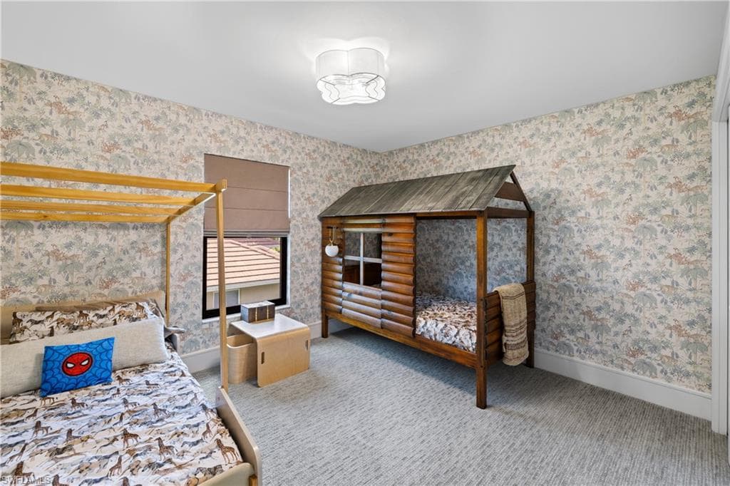 Room featuring patterned wallpaper, light-toned carpet flooring, and a flush-mount ceiling light fixture