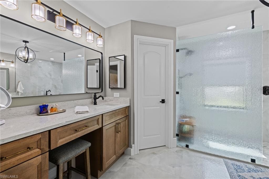 Bathroom featuring a large vanity with wood-finish cabinetry, a stone-finish countertop, and an integrated sink with a matte black faucet