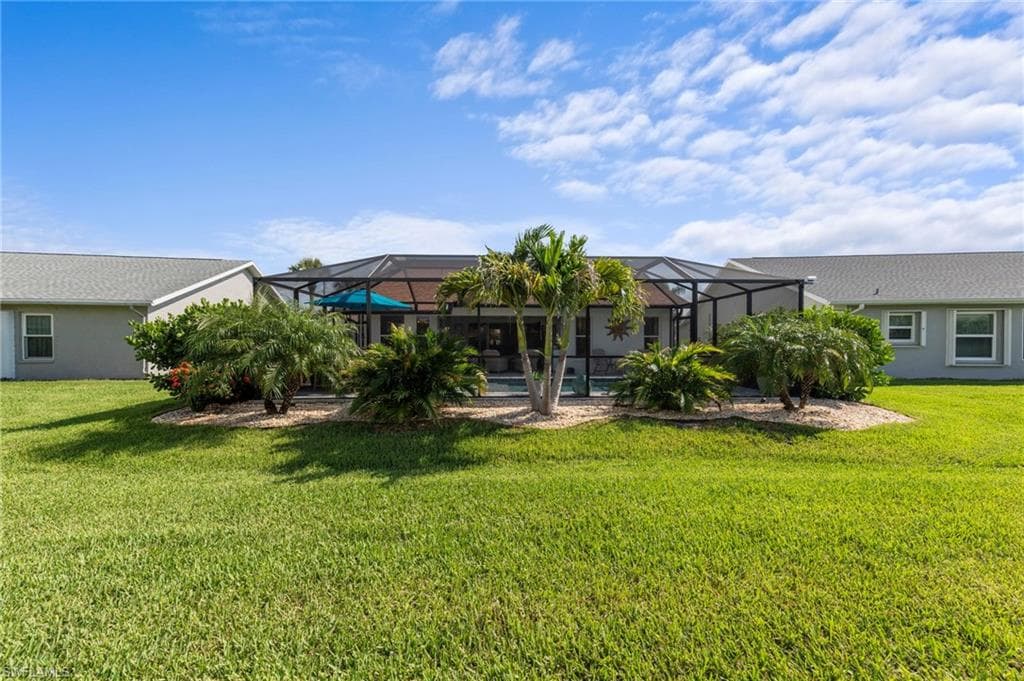 Backyard with mature palm trees, diverse tropical landscaping for privacy as well as a tropical feel from the pool