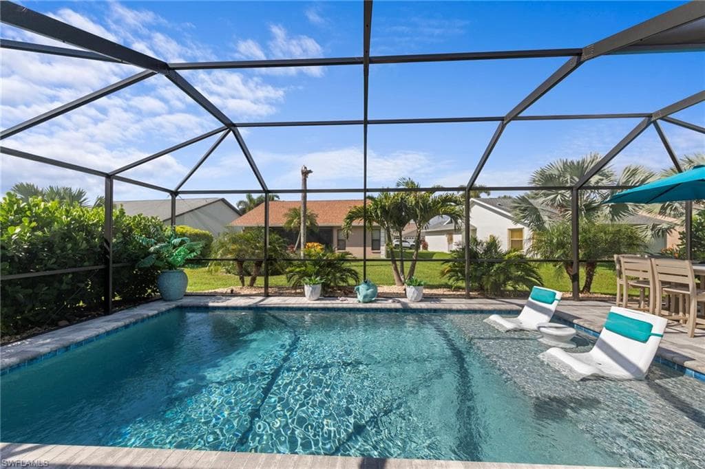 Screened pool enclosure featuring a beautiful saltwater pool with sun shelf for the ultimate relaxation