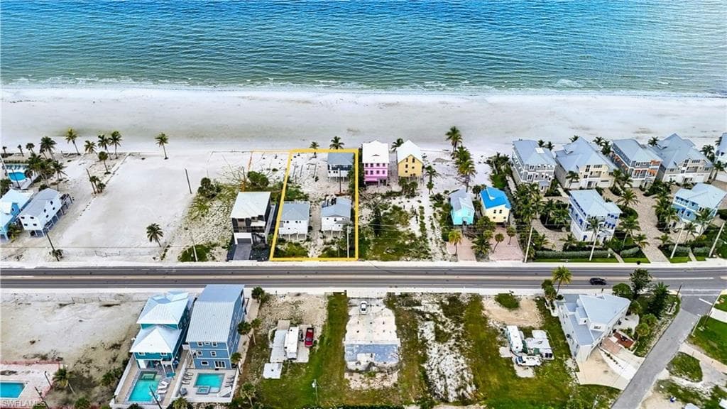 Beachfront property featuring direct access to the sand, established palm trees, and an open lot layout