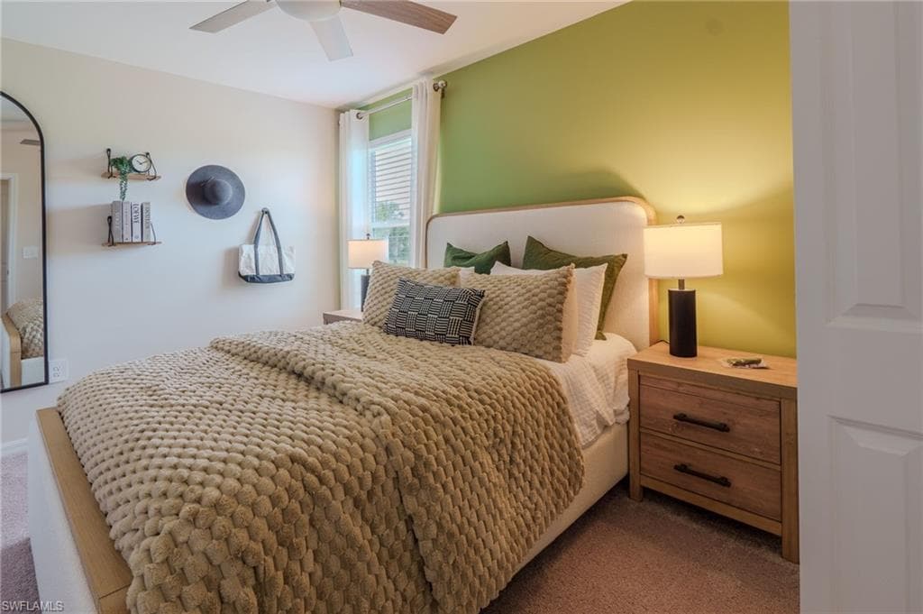 Bedroom featuring a ceiling fan, window with blinds, and light-colored carpeting