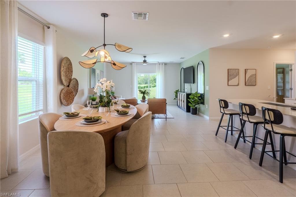 Open-concept dining area featuring a distinctive overhead light fixture and neutral tile flooring