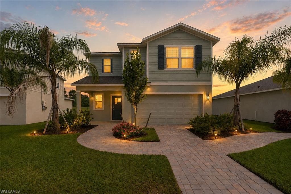 Two-story residence featuring light green siding and dark shutters
