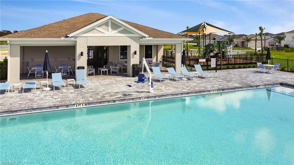 Resort-style swimming pool featuring integrated steps and a spacious surrounding paver deck