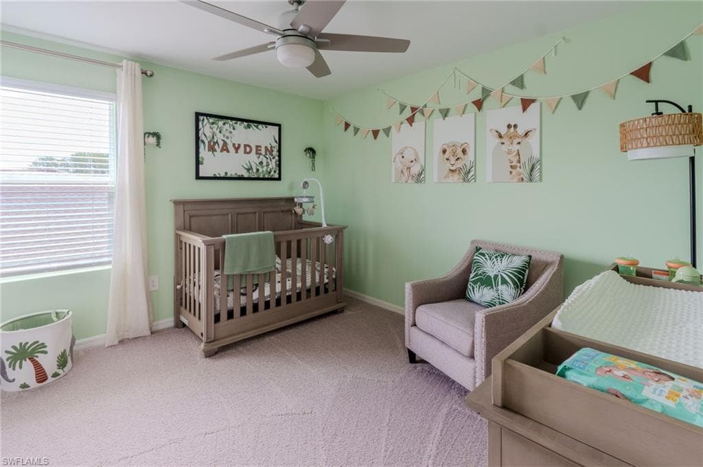 Room featuring light green wall paint, a ceiling fan with integrated lighting, a window with horizontal blinds, and neutral-toned carpet flooring