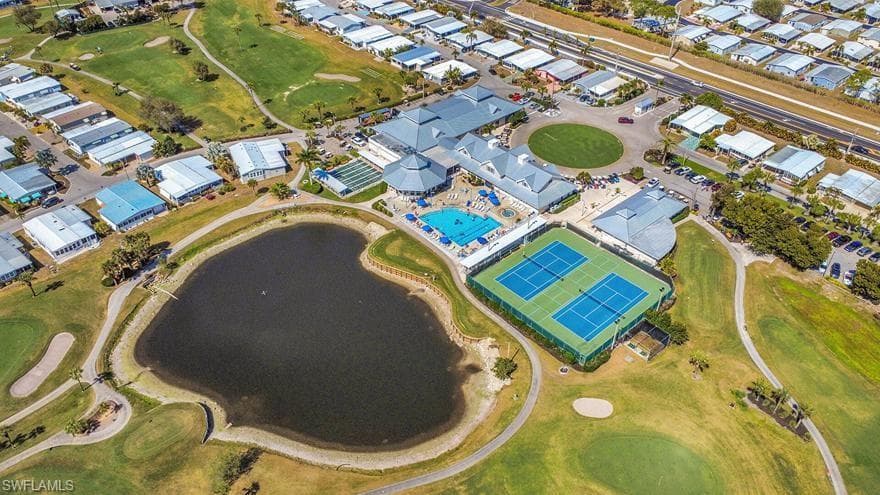 Central amenity complex featuring a large swimming pool, multiple tennis courts, and a clubhouse building