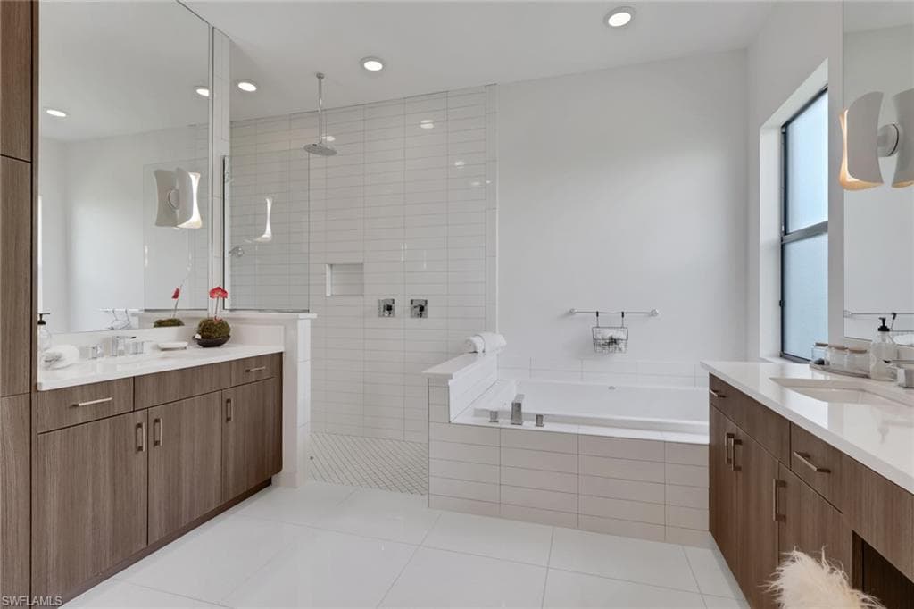 Dual vanities with ample storage space, custom lighting, spacious soaking tub, and a large, updated shower.