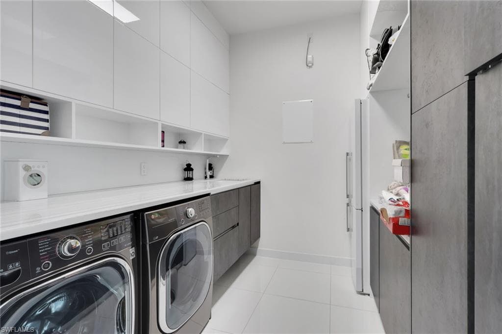Beautifully updated laundry room with marble countertops, folding area, ample storage space, extra fridge!
