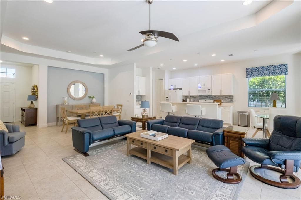 Open concept living area with tray ceiling and recessed lighting