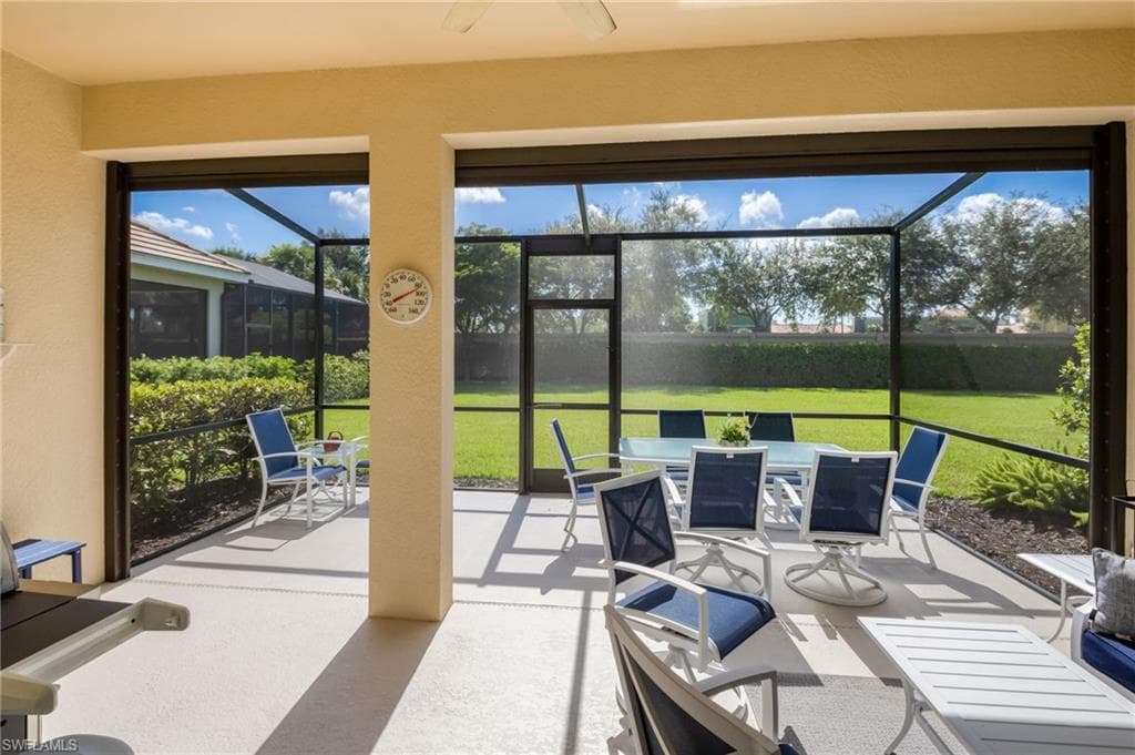 Expansive screened-in patio featuring a textured concrete surface and sturdy support columns
