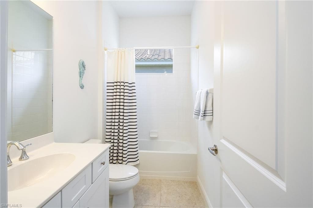 Bathroom featuring a white vanity with an integrated sink, polished chrome faucet, and a large wall-mounted mirror