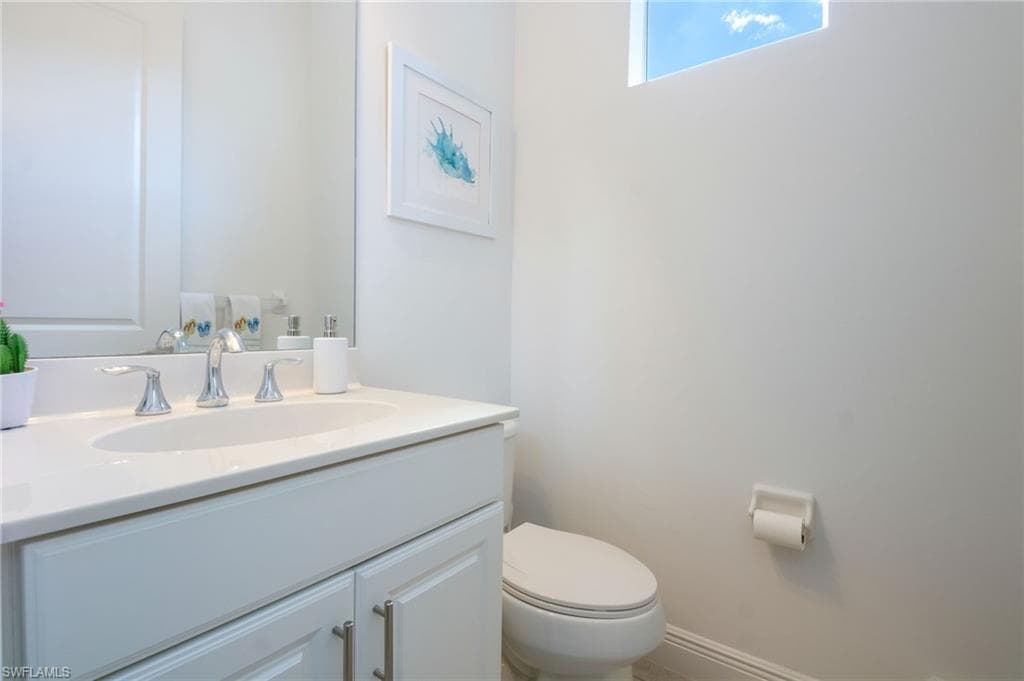 Vanity with an integrated sink, polished chrome faucet, and white cabinetry with brushed nickel hardware