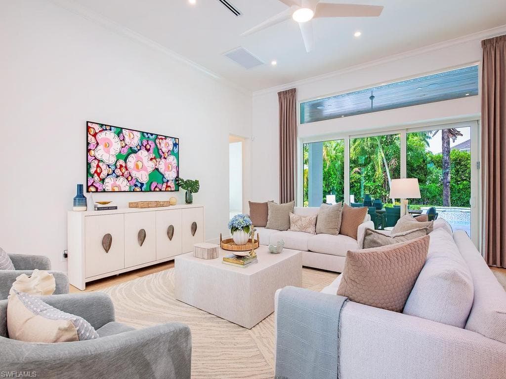 Spacious living area featuring large sliding glass doors, transom window, recessed lighting, and a ceiling fan