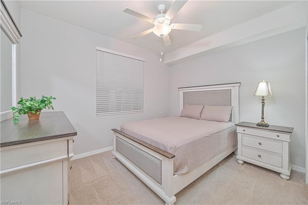 Comfortable guest bedroom featuring a spacious closet, neutral décor, ceiling fan, and convenient access to the guest bathroom.