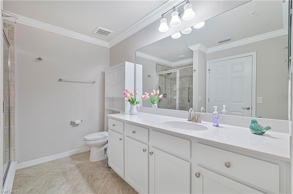 Spacious primary bathroom featuring an oversized dual-sink vanity, walk-in tiled shower, abundant storage, and a bright, open design.
