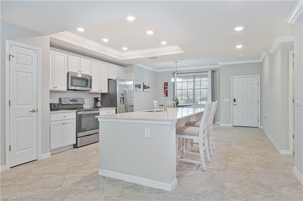 Beautiful quartz island kitchen featuring white cabinetry, stainless steel appliances, recessed lighting, and an open-concept design ideal for entertaining.