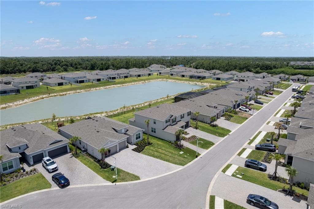 Aerial view of a residential community featuring a prominent central pond