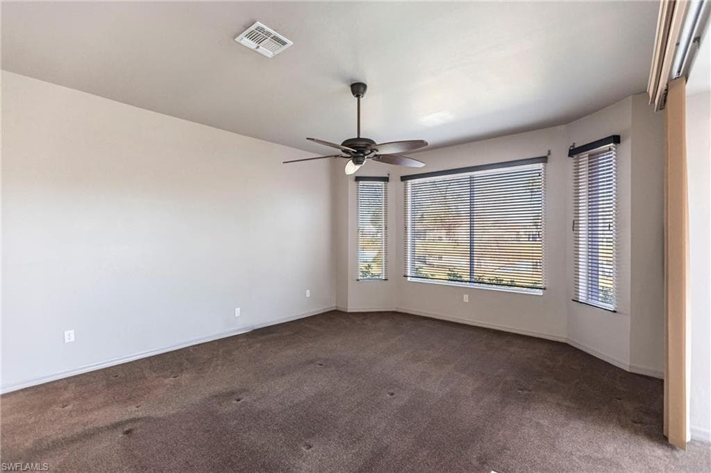 Featuring commercial grade, chocolate carpet and ceiling fan overlooking lake with manual shutters on all three windows