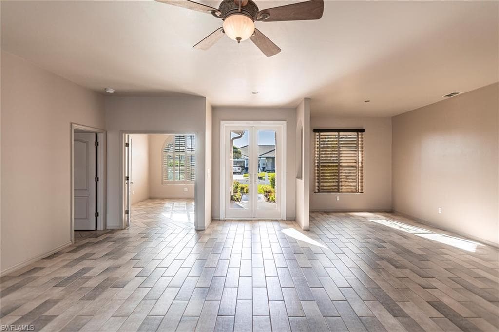 View of living room, dining room and den featuring Imported Italian ceramic tile and Hurricane rated custom dead bolt locking French front doors.