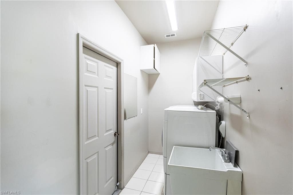 Washroom with technology (above) & storage cabinets, deep utility sink leading to garage.