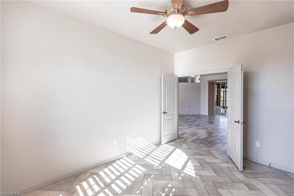 Looking out from den to living room and lanai with ceiling fan.