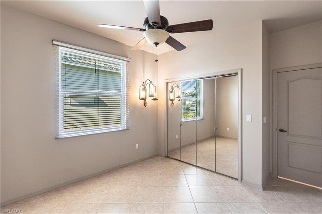 Guest bedroom with mirrored, spacious closet featuring built-ins with hurricane rated windows.
