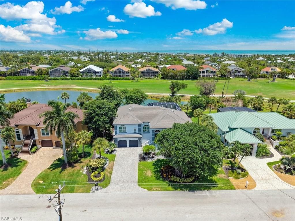 Coastal property featuring a golf course, water feature, and distant ocean scenery