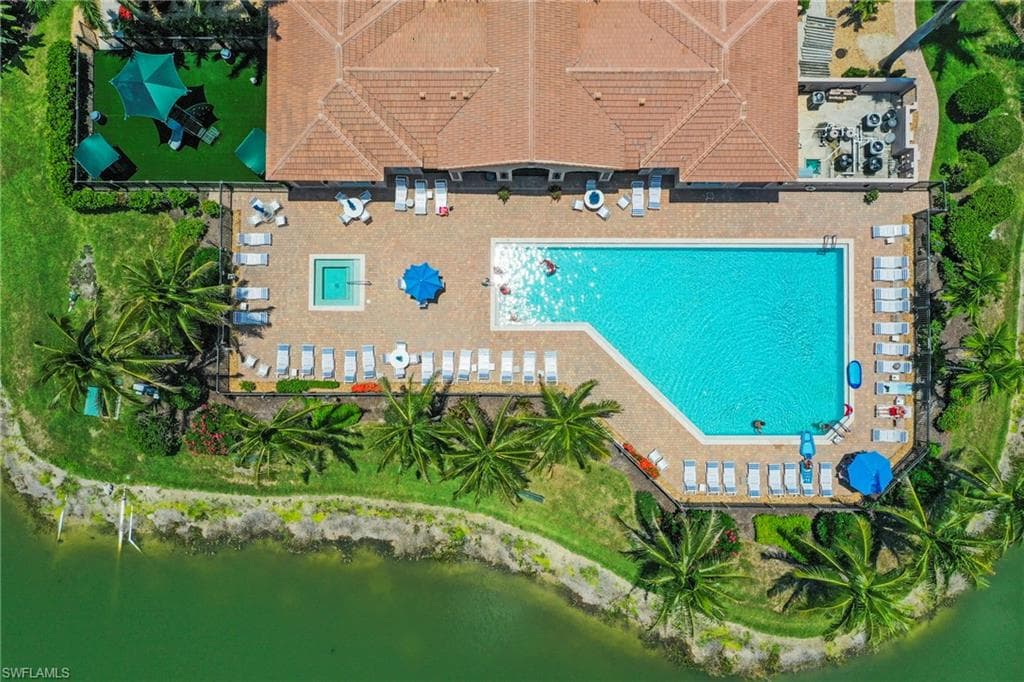 Expansive outdoor aquatic area featuring a large swimming pool and a separate spa