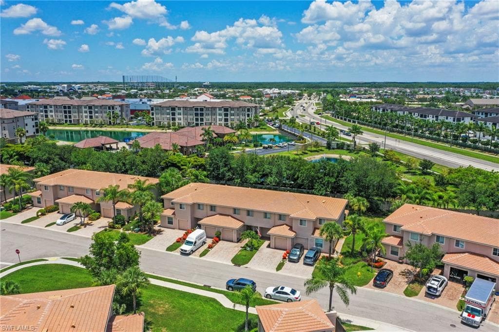 Aerial overview of a residential community featuring townhomes with attached garages and tile roofs