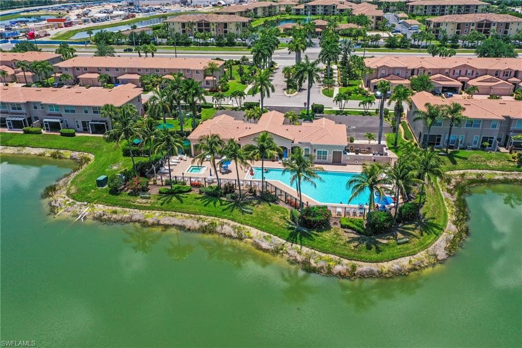Community swimming pool featuring a spa, surrounding patio, and lush landscaping