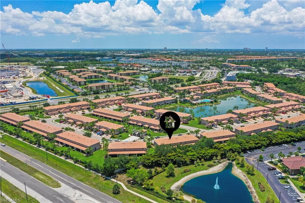 Aerial perspective showcasing a residential community with multiple multi-story buildings featuring terracotta-style roofs