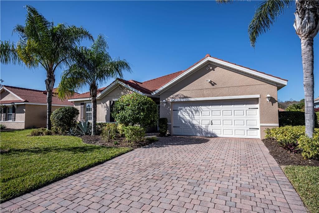 Single story home with a front yard and a garage